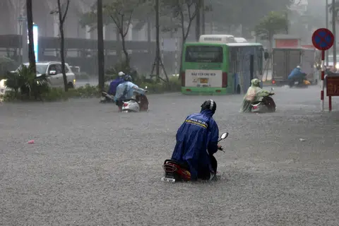Orang ramai meredah banjir sambil menolak motosikal mereka di sebuah jalan yang ditenggelami air di Hanoi, Vietnam, pada 30 September 2025. Taufan Bualoi telah meragut sekurang-kurangnya 19 nyawa, mencederakan puluhan orang dan menyebabkan beberapa lagi hilang sejak ia melanda kawasan utara-tengah Vietnam, menurut media negara.