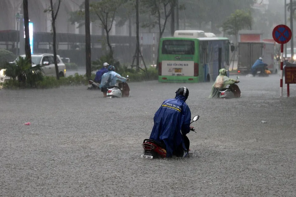 Orang ramai meredah banjir sambil menolak motosikal mereka di sebuah jalan yang ditenggelami air di Hanoi, Vietnam, pada 30 September 2025. Taufan Bualoi telah meragut sekurang-kurangnya 19 nyawa, mencederakan puluhan orang dan menyebabkan beberapa lagi hilang sejak ia melanda kawasan utara-tengah Vietnam, menurut media negara.