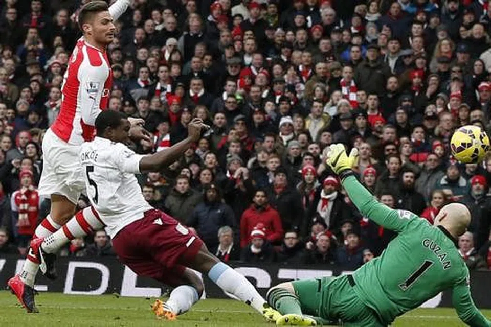 ARSENAL KEMBALI BERMAIN CEMERLANG: Penyerang antarabangsa Perancis, Olivier Giroud (jersi merah), menguis bola melepasi penjaga gawang Brad Guzan (kanan) untuk menjaringkan gol pertama Arsenal ketika menggilis Aston Villa 5-0 di Stadium Emirates malam kelmarin. - Foto AFP