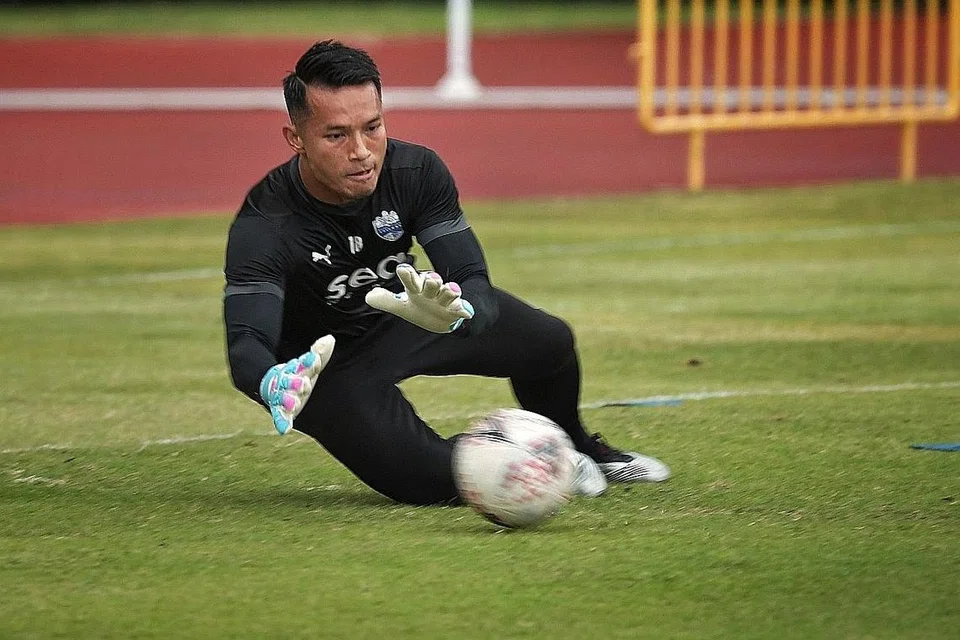 PELBAGAI TUGAS: Hassan Sunny kelihatan melayani pelanggan di gerai makannya di Tampines. Biarpun miliki gerai sendiri, tanggungjawab Hassan (gambar atas) sebagai pemain untuk kelab Liga Perdana Singapura (SPL), Lion City Sailors, tetap menjadi keutamaan. - Foto fail