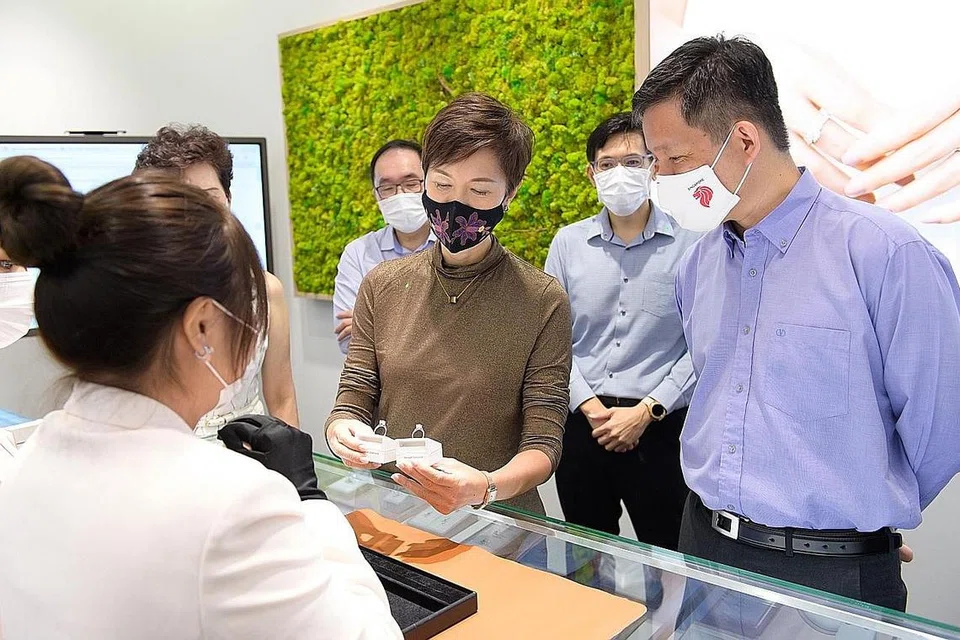 PELUANG MASIH ADA: Encik Chan (kanan) dan Cik Teo (tiga dari kanan) mengunjungi ibu pejabat SK Jewellery semalam untuk meninjau operasi syarikat setempat itu yang menggunakan teknologi dengan keadaan pasaran yang berubah supaya kekal berdaya saing. - Foto MTI