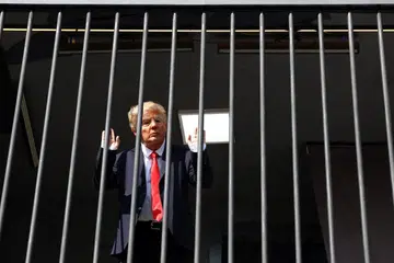 Seorang pelakon yang menyamar sebagai Presiden Amerika Syarikat, Encik Donald Trump, berdiri di sebalik jeriji besi dalam pemasangan seni menyerupai sel penjara di Dataran Tajrish, Tehran, Iran, pada 26 Oktober 2026. Amerika dilaporkan memberi amaran kepada sekutu Timur Tengah supaya bersiap menghadapi kemungkinan serangan baru terhadap Iran selepas pilihan raya pertengahan penggal pada 3 November, ketika usaha diplomatik dipergiat bagi mengelakkan konflik lebih besar.