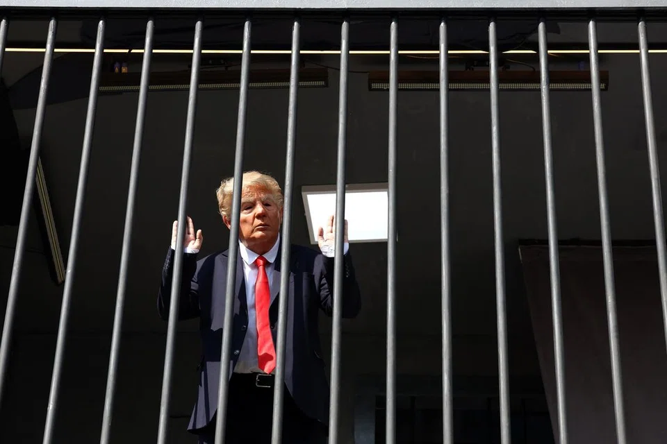 Seorang pelakon yang menyamar sebagai Presiden Amerika Syarikat, Encik Donald Trump, berdiri di sebalik jeriji besi dalam pemasangan seni menyerupai sel penjara di Dataran Tajrish, Tehran, Iran, pada 26 Oktober 2026. Amerika dilaporkan memberi amaran kepada sekutu Timur Tengah supaya bersiap menghadapi kemungkinan serangan baru terhadap Iran selepas pilihan raya pertengahan penggal pada 3 November, ketika usaha diplomatik dipergiat bagi mengelakkan konflik lebih besar.