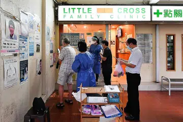 BANYAK PERTANYAAN: Beberapa orang menunggu di luar Little Cross Family Clinic di Blok 929 Tampines St 91 untuk menanyakan mengenai vaksin Sinovac. - Foto BH oleh LIM YAOHUI