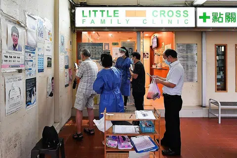 BANYAK PERTANYAAN: Beberapa orang menunggu di luar Little Cross Family Clinic di Blok 929 Tampines St 91 untuk menanyakan mengenai vaksin Sinovac. - Foto BH oleh LIM YAOHUI