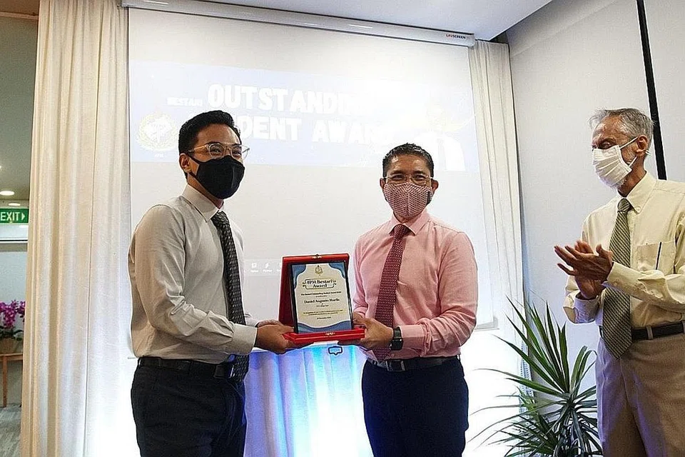 PELAJAR CEMERLANG: Dr Mohamad Maliki Osman (tengah) menyampaikan Anugerah Pelajar Cemerlang Bestari 4PM kepada Encik Daniel Augusto Murlis (kiri) sambil disaksikan Presiden 4PM, Encik Izzudin Taherally. - Foto 4PM