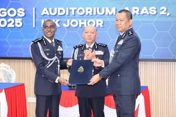 Datuk M Kumar (kiri), menyerahkan nota serah terima tugas kepada Pesuruhjaya Ab Rahaman Arsad (kanan), sambil disaksikan oleh Pengarah Jabatan Pengurusan Polis Diraja Malaysia (PDRM), Datuk Seri Abdul Aziz Abdul Majid.