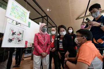 BERBAKAT SENI: (Dari kiri) Puan Halimah, Encik Yuen, Cik Ow, Cik Tan, Dr Maliki, dan Encik Yang Junwei (seorang guru) melihat karya seni pelajar Persekutuan Palsi Serebrum Singapura (CPAS), Mohamed Raziq Mohamed Zin (berbaju oren) di pameran Expressions Through Artdi Galeri Nasional Singapura semalam. - Foto BH oleh NG SOR LUAN