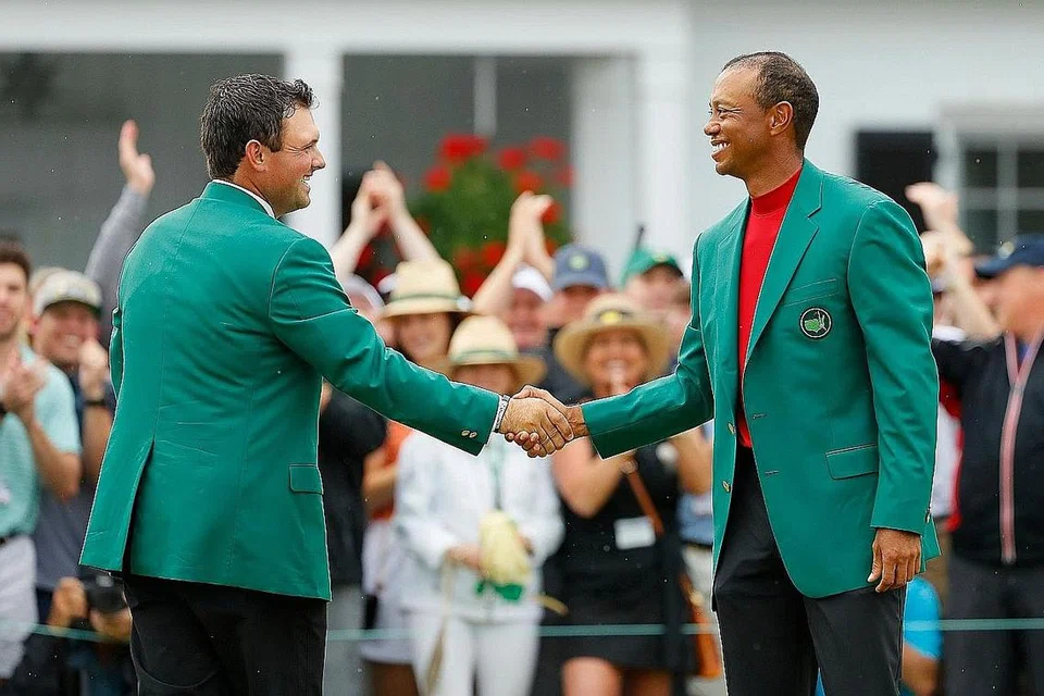 JABAT MESRA: Woods (kanan) berjabat tangan dengan juara Masters Patrick Reed semasa acara Jaket Hijau selepas memenangi Masters di Augusta pada 14 April lalu. - Foto AFP