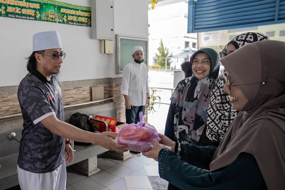 Naib Presiden, Alumni Madrasah Aljunied Singapura (Almas), Ustaz Bahrul-Ulum Buang, mengagihkan bubur kepada penduduk kawasan Geylang Bahru.