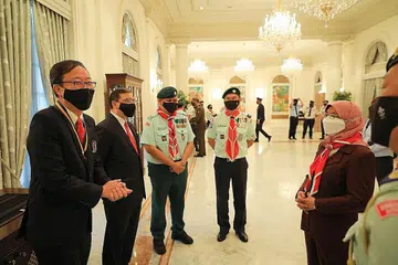 SUMBANGAN DIIKTIRAF: Presiden Halimah Yacob (kanan) bersembang dengan Penerima Pingat Emas Anugerah Perkhidmatan Cemerlang, Encik Tan Tee How (kiri) dan beberapa anggota pengakap sewaktu majlis penyampaian anugerah di Istana semalam. - Foto BH oleh ONG WEE JIN