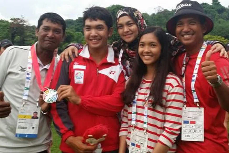 PINGAT PENDORONG SEMANGAT: Pemain golf muda berbakat, Abdul Hadi Uda (dua dari kiri), bergambar dengan bapanya, Uda Thith (kanan), ibunya, Erni M Kasim serta adiknya, Siti Hanaa. Paling kiri ialah Mohd Ibrahim Mohd Gaus, 'caddy' berpengalaman yang membantu Hadi sepanjang di Sukan SEA lalu. - Foto ihsan UDA THITH