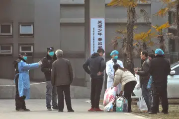 LANGKAH PENCEGAHAN: Pakar kesihatan serta pegawai keselamatan China memberi amaran kepada keluarga golongan pesakit agar mereka tidak berada terlalu dekat dengan Hospital Jinyintan di wilayah Hubei di Wuhan. Ini penting kerana ia akan memastikan pesakit pneumonia yang turut menghidapi koronavirus itu dapat dirawat dengan segera. - Foto REUTERS