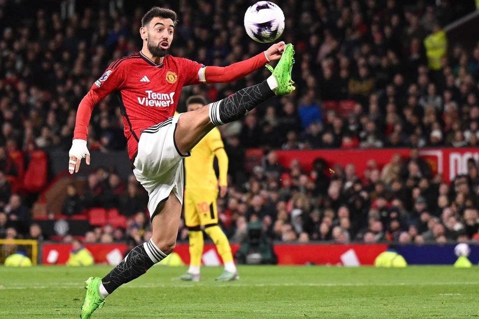 Pemain tengah Manchester United, Bruno Fernandes, mengawal bola semasa perlawanan EPL menentang Sheffield United di Old Trafford  pada 24 April.