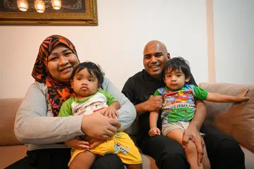 BANTU JAGA ANAK: Meski buta, Encik Mohamed Rahamatulla Ibrahim Sahib memainkan peranan aktif dalam penjagaan dua anaknya – Mohamed Shameer (atas pangkuan bapanya) dan Mohamed Rayan – supaya dapat memberi sokongan kepada isterinya, Cik Shamsiah Osman, seperti memandikan anak, menukarkan lampin dan membuatkan susu untuk si kecil.
