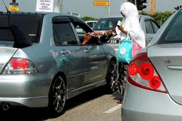 TEMPAT TUMPUAN: Pengemis di sekitar Johor Baru dilaporkan sering menjadikan kawasan sibuk seperti dekat lampu isyarat sebagai tempat menjalankan kegiatan kerana mereka dapat memperoleh lebih banyak wang dan lebih mudah bagi mereka melarikan diri apabila ternampak kenderaan penguatkuasaan (yang tidak sempat menahan mereka disebabkan kesesakan). - Foto NSTP