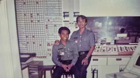 Encik Taib (kanan) ketika bertugas di bilik operasi Pulau Bukom pada tahun 80-an.