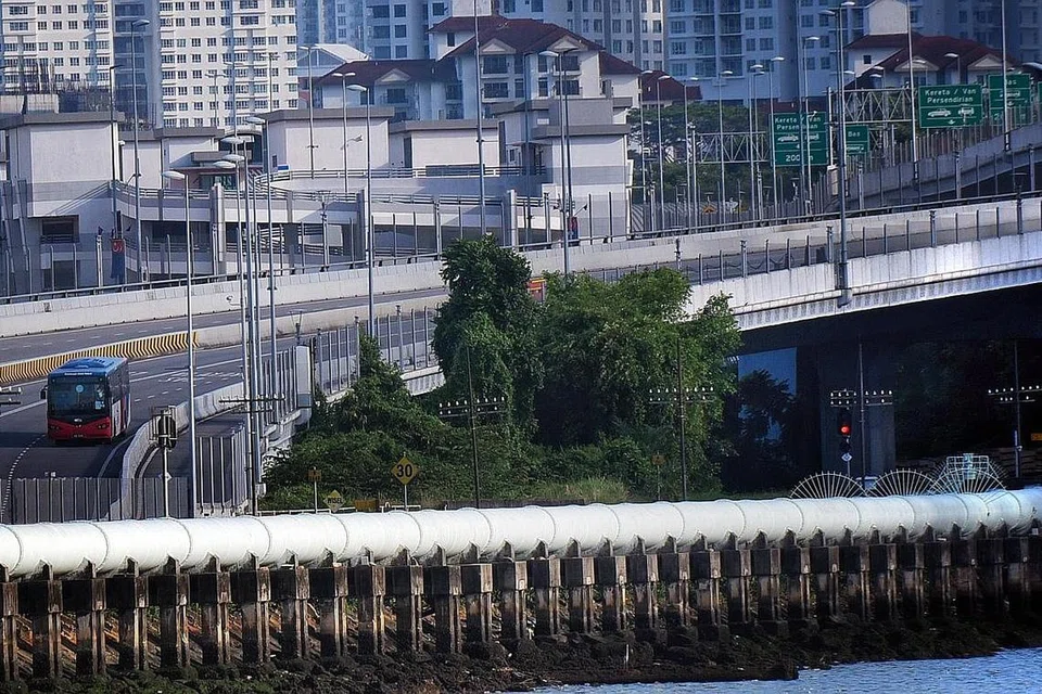 GARA-GARA JANGKITAN MENINGKAT: Sebuah bas (kiri) yang disediakan secara percuma oleh Perbadanan Pengangkutan Awam Johor (PAJ) membawa pejalan kaki dari Johor ke Pusat Pemeriksaan Woodlands di Koswe Ogos lalu, di bawah perjanjian RGL dan PCA. RGL akan digantung selama tiga bulan oleh Singpura mulai esok. - Foto fail BH