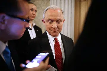 DAPAT SOKONGAN TIPIS: Encik Jeff Sessions (tengah) berbual dengan wartawan selepas dewan Senat mengesahkan pelantikan beliau sebagai Peguam Negara. - Foto AFP