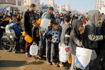 Gambar yang dipetik pada 4 Januari 2024 menunjukkan penduduk Palestin beratur sementara menunggu untuk mendapatkan air minuman, ketika konflik antara Israel dengan Hamas berterusan, di Rafah, di selatan Jaluran Gaza.