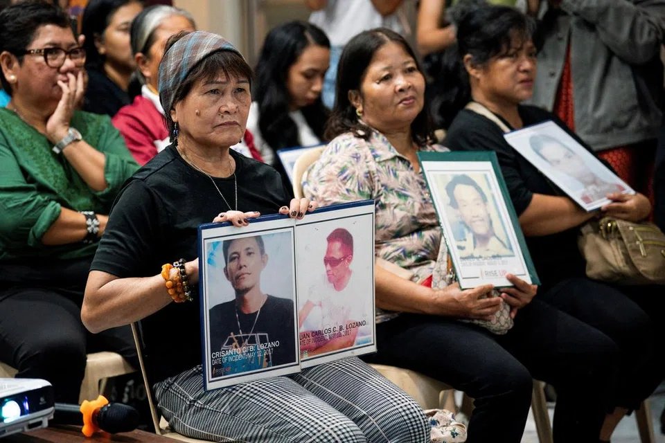 Para balu dan ibu memegang gambar suami atau anak yang terkorban akibat tindakan keras terhadap dadah yang merupakan dasar utama pemerintahan Encik Duterte.