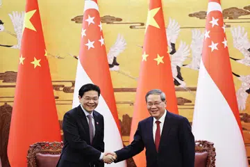 Perdana Menteri, Encik Lawrence Wong (kiri), dan Perdana Menteri China, Encik Li Qiang, berjabat tangan di akhir satu majlis menandatangani perjanjian yang diadakan di Beijing, China pada 23 Jun.