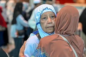 Cik Sarimah Amir (kiri) berpelukan bersama ahli keluarganya sebelum beliau berangkat untuk menunaikan ibadah haji pada 3 Jun.