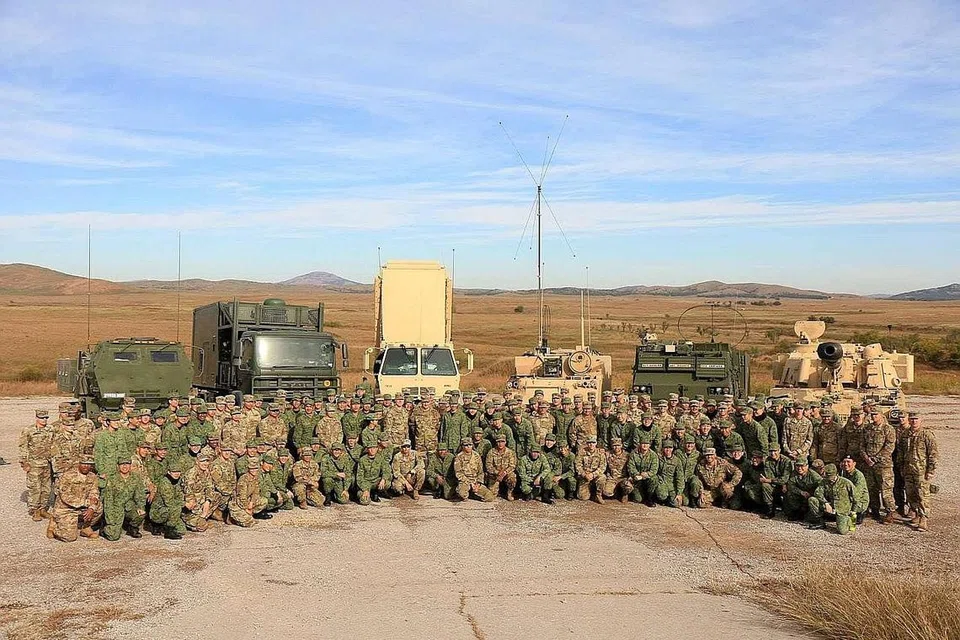 PUPUK HUBUNGAN ERAT: Askar SAF dari Batalion ke-23 bergambar dengan askar Amerika dari Batalion Kedua, Rejimen Meriam Padang ke-18. Menurut Mindef, sejumlah 150 kakitangan SAF dan 70 kakitangan tentera Amerika menyertai Latihan Daring Warrior 2018, yang ketujuh diadakan sejak 2010. - Foto: KEMENTERIAN PERTAHANAN