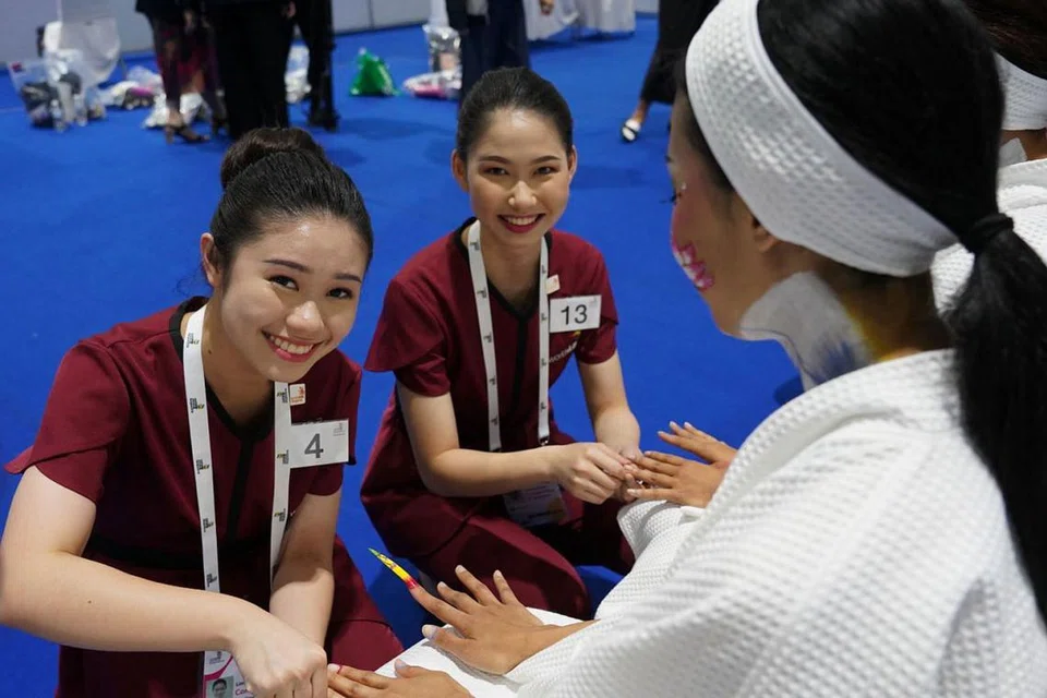 PRESTASI BAIK: Cik Lim Hui Fang (kiri), pelajar tahun kedua di ITE, meraih pingat emas bagi acara terapi kecantikan dalam pertandingan WorldSkills Asean baru-baru ini yang diadakan di Bangkok. Rakannya, Cik Vanessa Kow (tengah), meraih pingat perak dalam kategori yang sama. - Foto WORLDSKILLS SINGAPORE OFFICE
