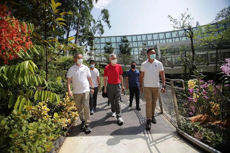 (tengah) Perdana Menteri ee Hsien Loong dan (dua dari kanan) Menteri Pembangunan Negara, Encik Desmond Lee, sedang bersiar-siar di pameran, Tropical Montane Orchidetum di Taman Orkid Negara. 