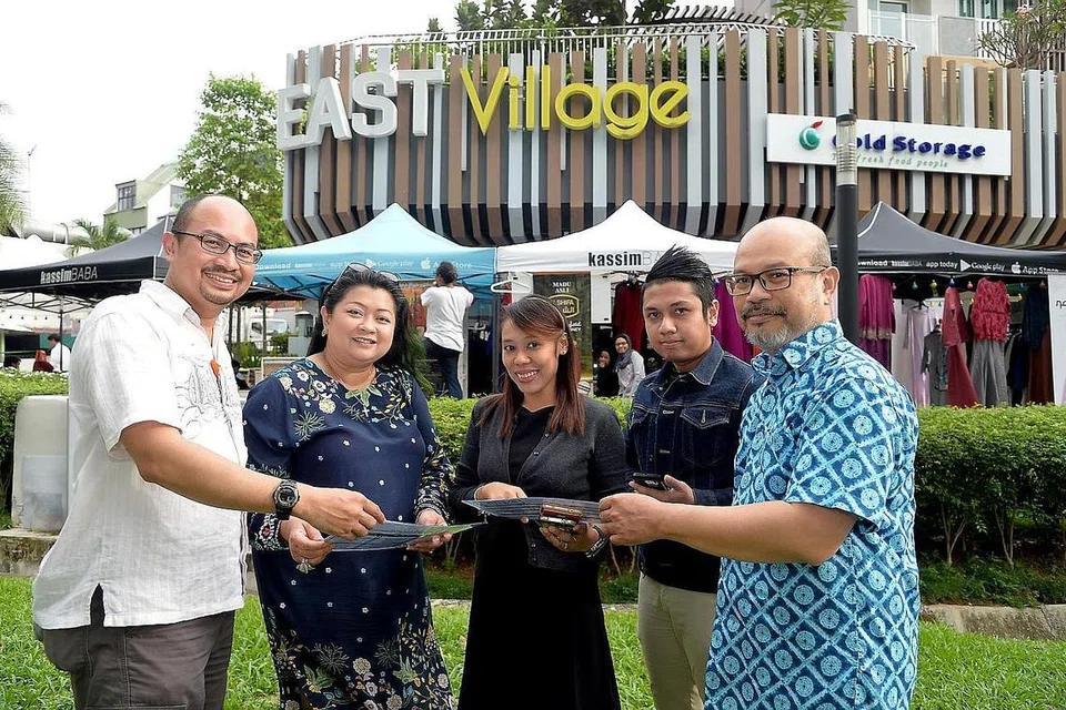 PENGANJUR BERSAMA: Sekumpulan peniaga ini - (dari kiri) Syed Ali Syed Hussin, Cik Regina Cornelius, Cik Diana Haron, Encik Mohammad Faris Omar dan Encik Mohd Khir Bohari - berganding bahu menjayakan bazar Ramadan pertama di East Village.