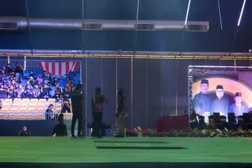 KURANG SIAP: Para penganjur dilihat menukar dan memperbetulkan tikar pada beberapa bahagian gelanggang sekitar 10 pagi semalam, iaitu waktu perlawanan dijadual bermula. - Foto BH oleh ZULAIQAH ABDUL RAHIM