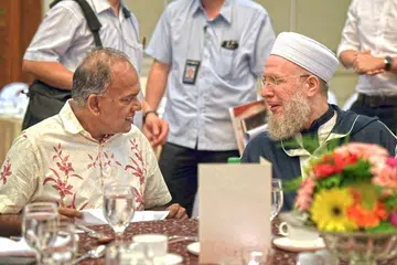 BERSATU DALAM MENENTANG ISIS: Encik Shanmugam (kiri) berbincang dengan Shaykh Sayyid Muhammad Al-Yaqoubi semasa majlis makan tengahari sempena Rahat RRG semalam. - Foto BH oleh ALPHONSUS CHERN