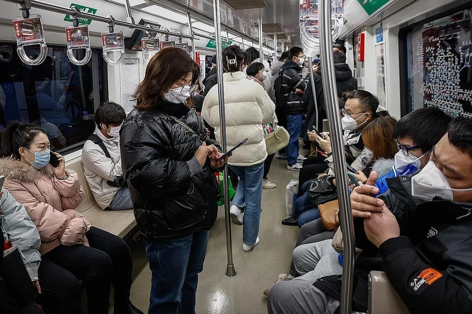 PAKAI PELITUP: Orang ramai memakai pelitup di dalam kereta api di Beijing, China, sebagai langkah mencegah jangkitan virus Covid-19 di tengah-tengah lonjakan kes jangkitan penyakit tersebut di negara itu. - Foto EPA-EFE