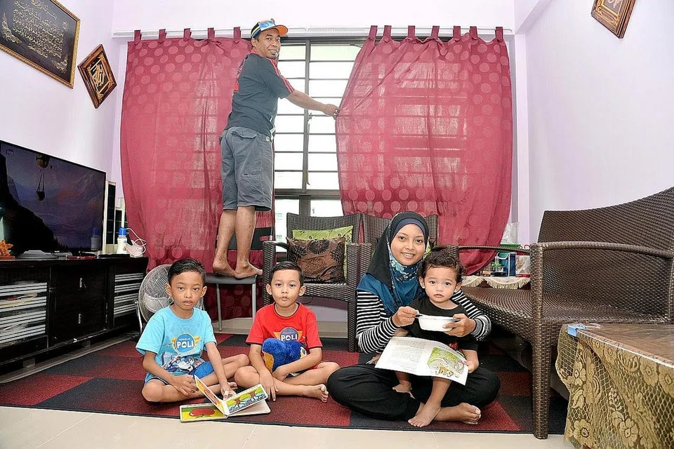 AKHIRNYA MILIKI RUMAH: Encik Hizar bersama isterinya Cik Herdahwati dan tiga anak lelaki mereka baru berpindah ke flat tiga bilik mereka sendiri di Yishun beberapa bulan lalu, setelah enam tahun duduk di flat sewa. - Foto M.O. SALLEH