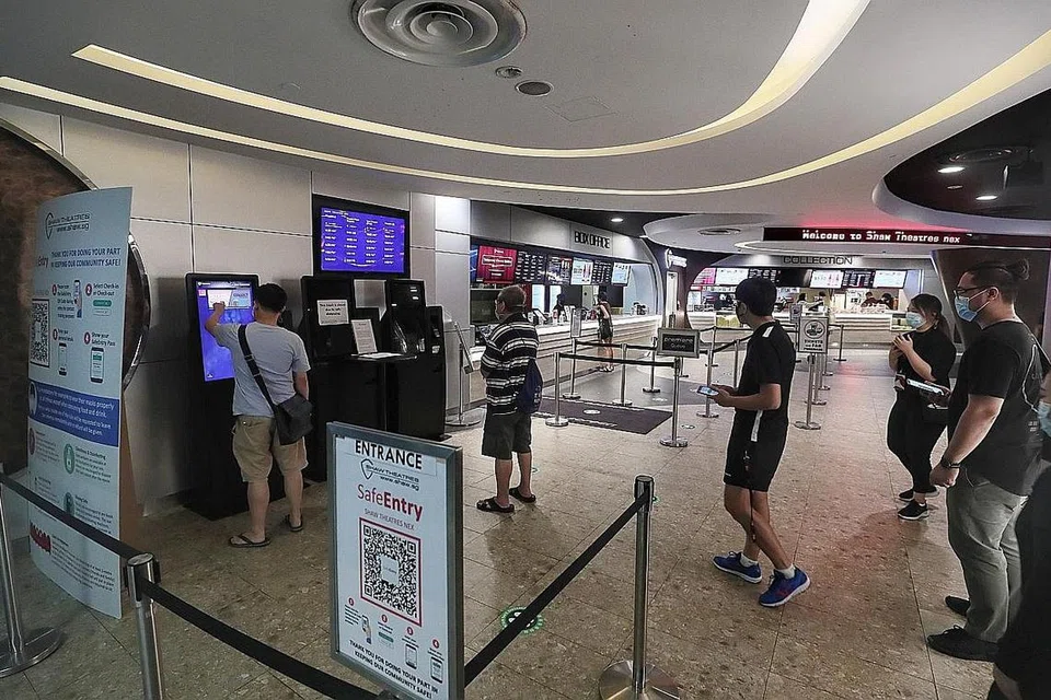 Langkah jarak selamat dalam pawagam dan ketika beratur (gambar atas) dipatuhi. - Foto BH oleh KELVIN CHNG