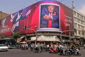 Penunggang motosikal melintasi papan iklan yang memaparkan Presiden Amerika Syarikat, Encik Donald Trump, di pusat bandar Teheran, Iran, pada 31 Ogos. Iran melancarkan serangan peluru berpandu dan dron ke arah sasaran tentera Amerika di Timur Tengah sebagai tindak balas terhadap serangan Washington di Pulau Larak di Selat Hormuz. Pertempuran itu merupakan pertukaran serangan pertama antara kedua-dua pihak dalam tempoh lebih sebulan. Selepas enam bulan perang, Iran terus menyekat Selat Hormuz, manakala Amerika mengekalkan sekatan balas melalui operasi tentera lautnya.