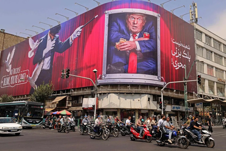 Penunggang motosikal melintasi papan iklan yang memaparkan Presiden Amerika Syarikat, Encik Donald Trump, di pusat bandar Teheran, Iran, pada 31 Ogos. Iran melancarkan serangan peluru berpandu dan dron ke arah sasaran tentera Amerika di Timur Tengah sebagai tindak balas terhadap serangan Washington di Pulau Larak di Selat Hormuz. Pertempuran itu merupakan pertukaran serangan pertama antara kedua-dua pihak dalam tempoh lebih sebulan. Selepas enam bulan perang, Iran terus menyekat Selat Hormuz, manakala Amerika mengekalkan sekatan balas melalui operasi tentera lautnya.