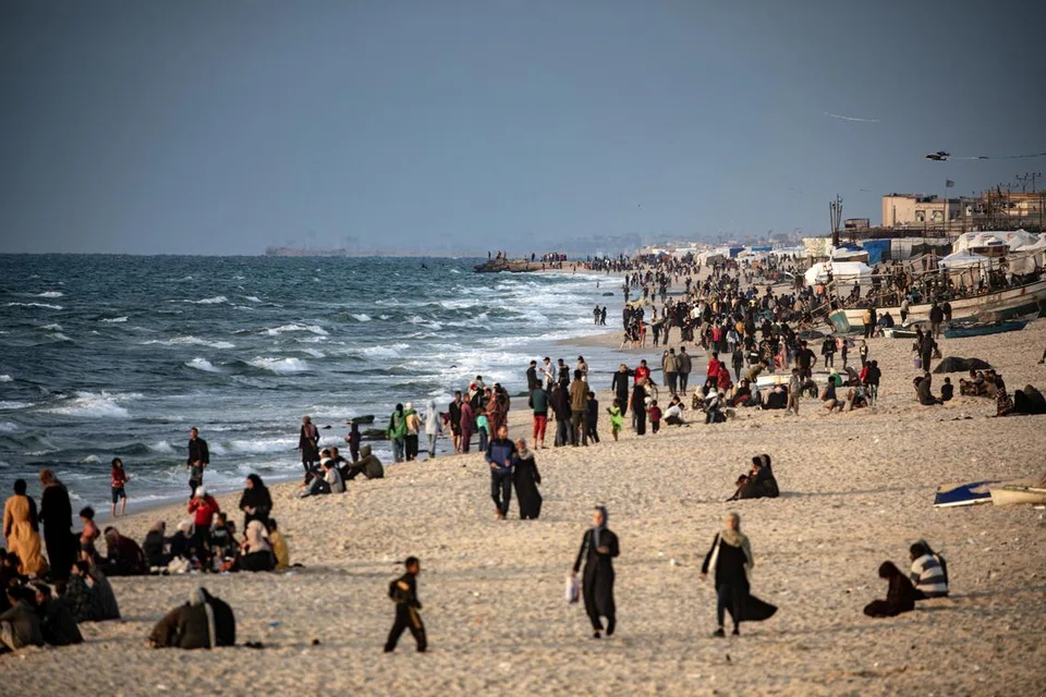 Penduduk Palestin menghabiskan masa di pantai berdekatan dengan kem pelarian Rafah, selatan Jaluran Gaza,  pada 13 April sedang Israel menangguhkan rancangan untuk melancarkan serangan darat di Rafah.