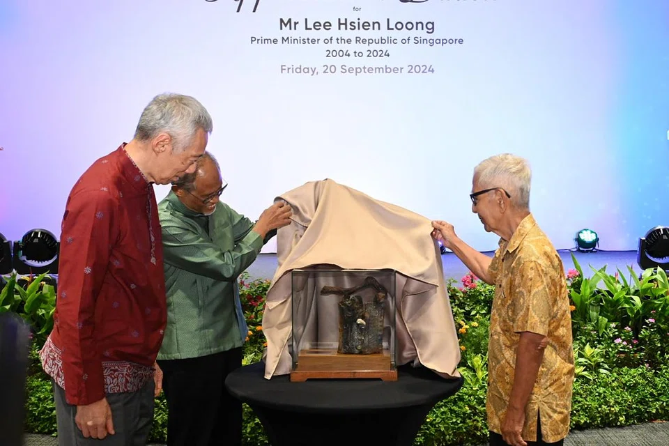 Menteri Kanan Lee Hsien Loong (kiri) diberi hadiah penghargaan istimewa berupakan arca yang dihasilkan oleh pakar tembikar dan penerima Pingat Kebudayaan, Dr Iskandar Jalil (kanan). Turut disaksikan oleh Menteri Bertanggungjawab bagi Ehwal Masyarakat Islam, Encik Masagos Zulkifli Masagos Mohamad (dua dari kanan).  