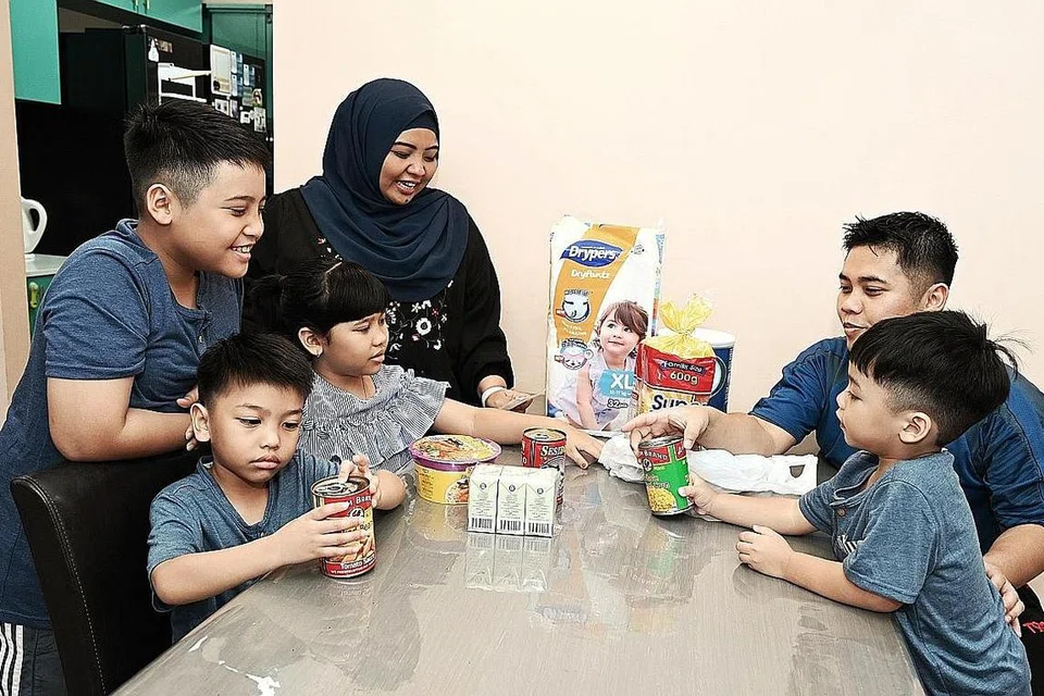 LEBIH BERJIMAT: Cik Nur Diana dan suami Encik Zulfiqar bersama empat anaknya menyemak resit pembelian barangan dapur bagi memastikan ia tidak melebihi bajet bulanan. - Foto BH oleh KHALID BABA