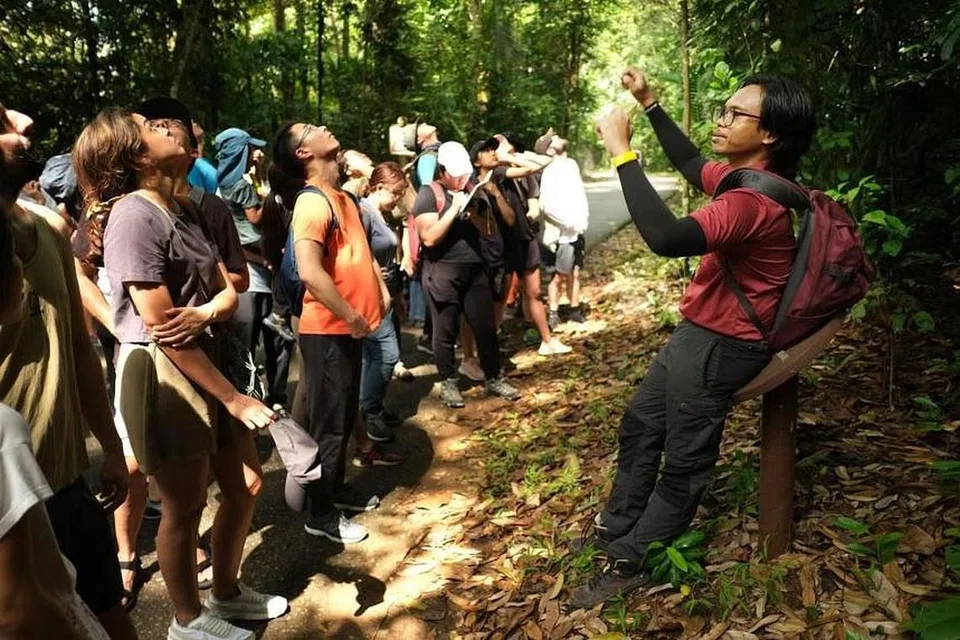 Encik Nor Syazwan Abdul Majid (kanan) menganjurkan satu lawatan berpandu di sekitar Pulau Ubin dan menceritakan kepada para pelawat tentang kekayaan warisan budaya di pulau itu.