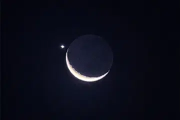 HIASI LANGIT MALAM: Pemandangan bulan sabit diiringi planet Zuhrah menghiasi langit malam pada Jumaat, 24 Mac. - Foto ST