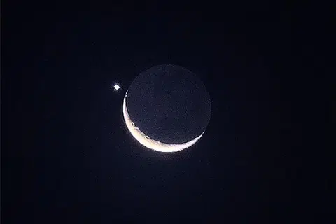 HIASI LANGIT MALAM: Pemandangan bulan sabit diiringi planet Zuhrah menghiasi langit malam pada Jumaat, 24 Mac. - Foto ST