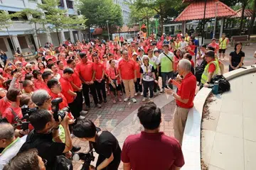 Menteri Kanan, Encik Lee Hsien Loong berucap kepada para sukarelawan dan penduduk sebelum mereka memulakan perjalanan berjalan kaki ke Kelab Masyarakat Ci Yuan.