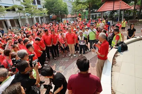 Menteri Kanan, Encik Lee Hsien Loong (kanan), berucap kepada para sukarelawan dan penduduk sebelum mereka memulakan perjalanan berjalan kaki ke Kelab Masyarakat Ci Yuan.