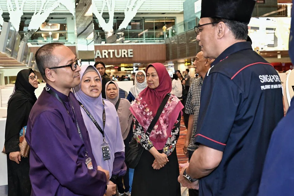 Pasangan suami isteri, Encik Redzuan Abdullah (kiri) dan Cik Marhamah Mohd Sidik (dua dari kiri) telah mendaftar untuk menunaikan haji sejak Oktober 2013 dan hanya menerima tawaran pada November 2024. Bersama mereka pada hari berangkat ialah Ketua Delegasi Haji Singapura 2025, Encik Kadir Maideen (kanan).