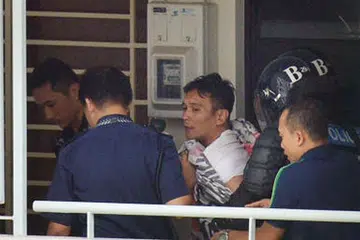 DIJATUHI HUKUMAN: Muhammad Iskandah Suhaimi (berbaju putih) menahan anak lelaki teman wanitanya sebagai tebusan selama 17 jam di sebuah flat di Sembawang pada 27 September 2016. Dia dikenakan hukuman jel dan rotan. - Foto fail