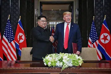 PENUH MESRA: Presiden Amerika Donald Trump dan pemimpin Korea Utara Kim Jong Un, yang pernah saling mengecam, bertemu dalam suasana penuh mesra (gambar atas) mengakhiri sidang puncak mereka di Singapura dengan kenyataan bersama yang membuka jalan bagi dunia yang lebih aman. - Foto BM oleh KEVIN LIM