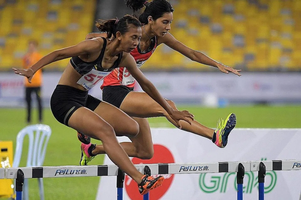MEMBERANGSANGKAN: Dipna Lim-Prasad (kanan) bersaing hebat dengan peserta Thailand, Jutamas Khonkham, untuk memenangi pingat perak perlumbaan 400 meter berpagar. - Foto THE STRAITS TIMES
